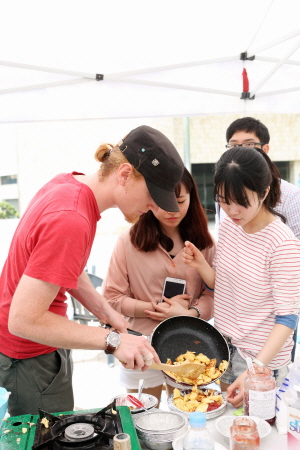 외국인 버디가 한국인 버디에게 요리를 판매하고 있다.